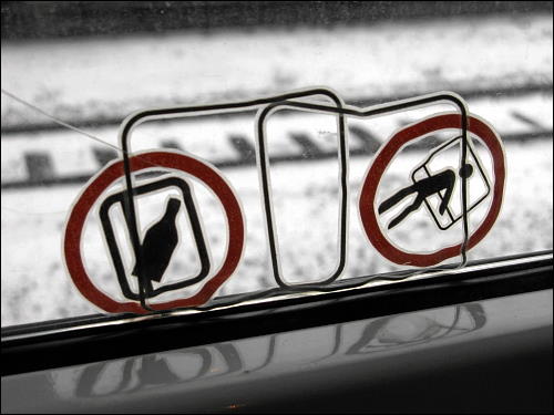 verrutschte Piktogramme am Fenster eines Regionalzuges